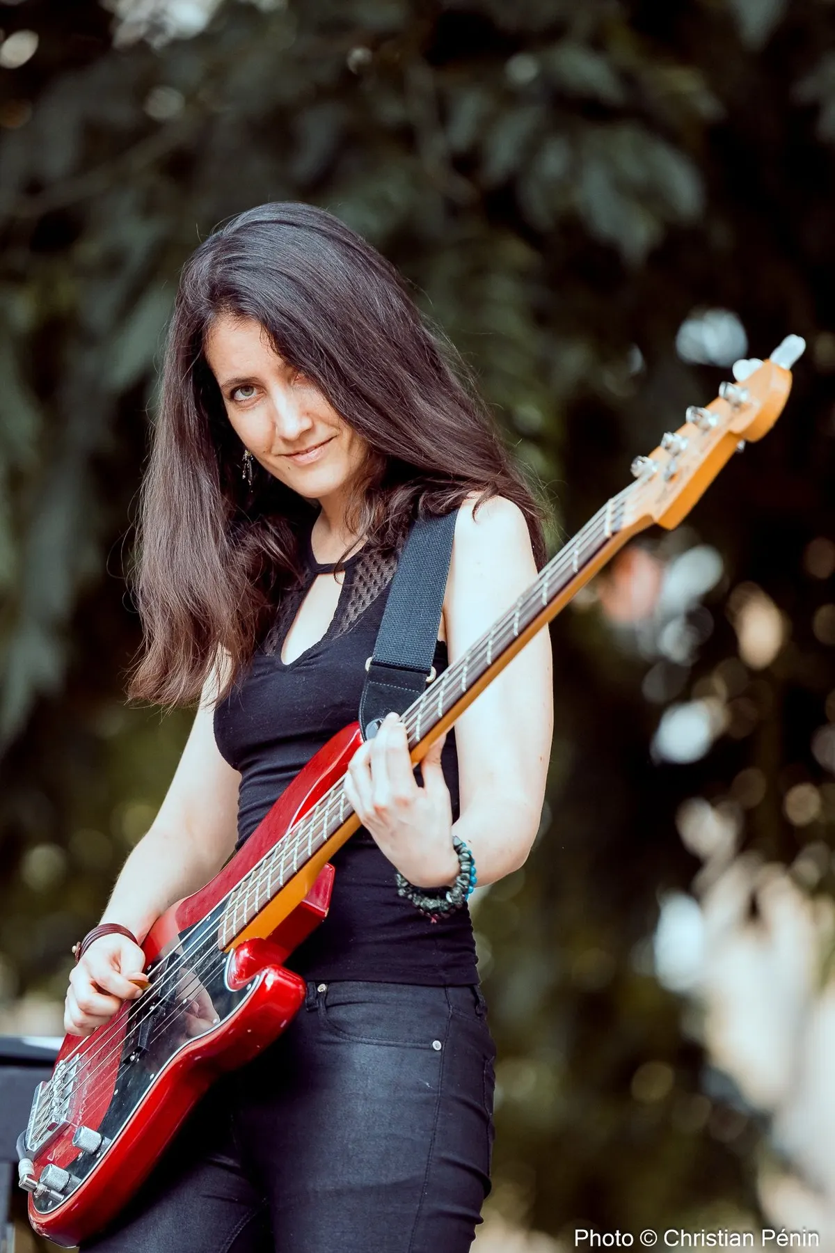 LesJACK : la bassiste et sa basse rouge, en plein air