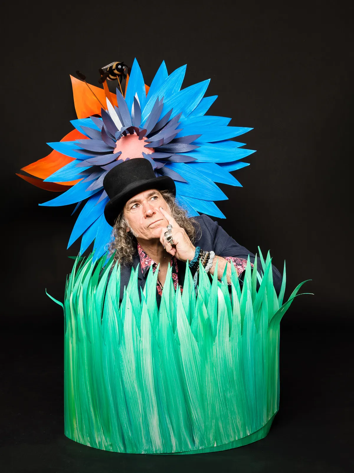 LesJACK : le chanteur en chapeau haut-de-forme sous une grande fleur bleue en papier