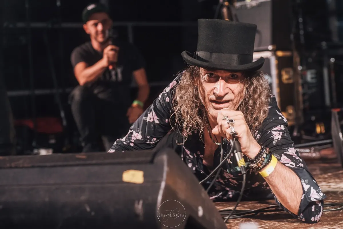 LesJACK : le chanteur en chapeau haut-de-forme penché vers le public